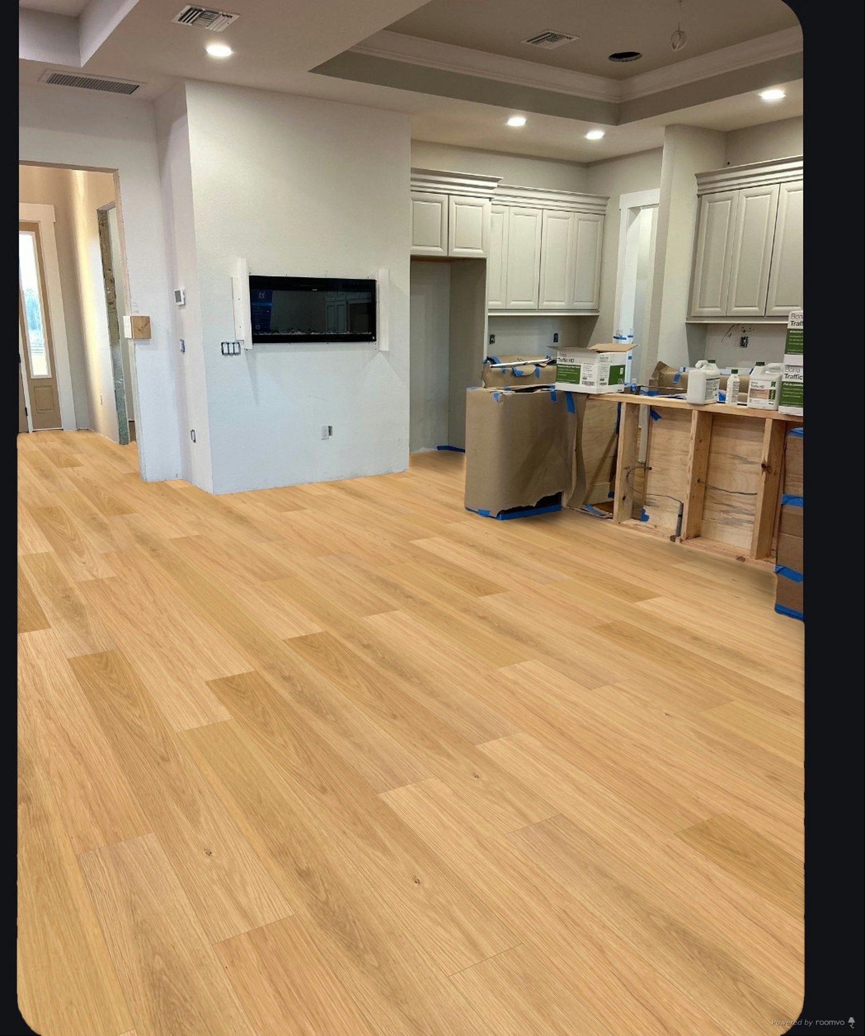 Light oak wood plank flooring installed in a residential kitchen and living area, showing the natural wood grain and color in a real home environment.